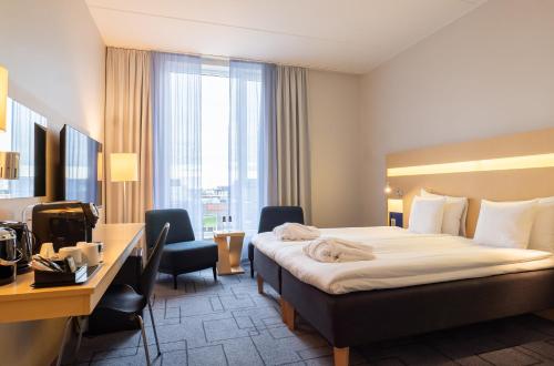 Best Western Plus Park City Malmö في مالمو: غرفة في الفندق مع سرير ومكتب