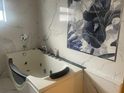 a bathroom with a bath tub and a mirror at Grey Orchard Homestay - A Family Place in Lahore