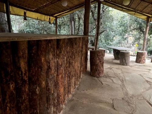 a picnic shelter with a table and a bench at Glampinn Woods in Nainital