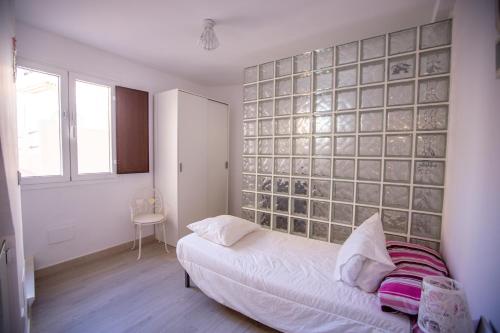 una camera con un letto e una parete con piastrelle in vetro di Casita Centro Almuñecar ad Almuñécar