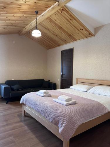 a bedroom with a large bed and a couch at Bala's House in Mestia