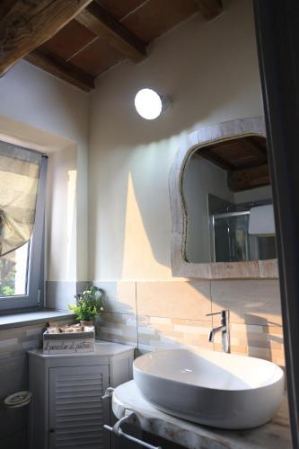 a bathroom with a sink and a large mirror at Il Paradiso di Pietra in Filetto