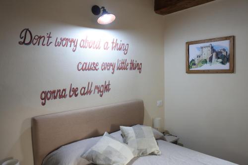 a bedroom with a bed with words on the wall at Il Paradiso di Pietra in Filetto
