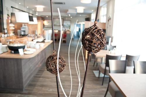 two baskets on sticks in a restaurant with a counter at Amaro Hotel in Bergkirchen