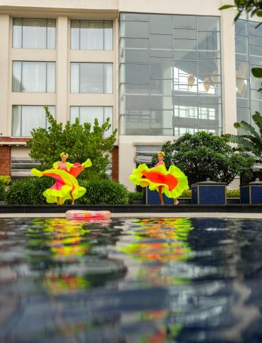a pool of water with figurines in front of a building at The Westin Goa in Vagator