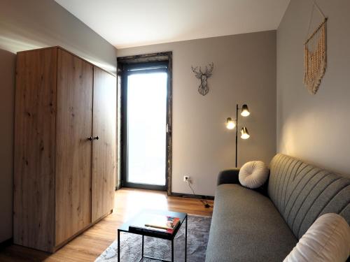 a living room with a couch and a large window at Mokre 22 in Bielsk Podlaski