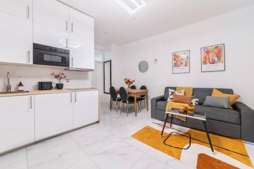 une cuisine et un salon avec un canapé et une table dans l'établissement Convention-Vaugirard -Salon des Expositions-Versailles, à Paris