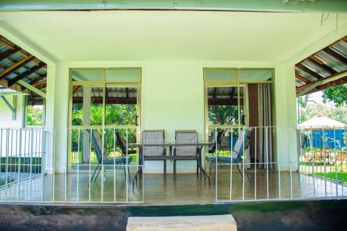 a screened in porch with chairs and a table at Harry's Kisumu Oasis in Kisumu