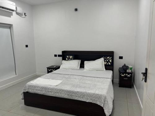 een slaapkamer met een groot bed met witte lakens en kussens bij Tropical oasis in Trivandrum
