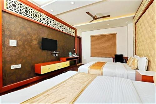 a hotel room with two beds and a flat screen tv at HOTEL MGM RESIDENCY in New Delhi