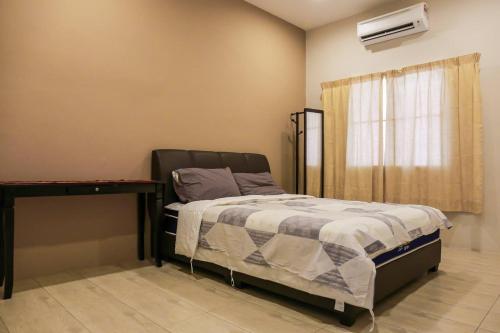 a bedroom with a bed and a desk and a window at D Zorro HomeTel in Ipoh