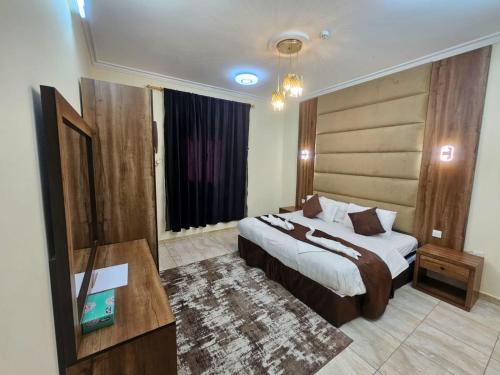 a hotel room with a bed and a desk and a room at الرموز الصادقة للشقق المخدومة Apartments alrumuz alsadiqah in Jeddah