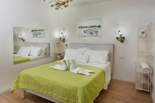 a bedroom with two beds with towels on a green blanket at עדנת האוהבים - סוויטות קסומות ליד הכנרת עם בריכה משותפת במגדל in Migdal