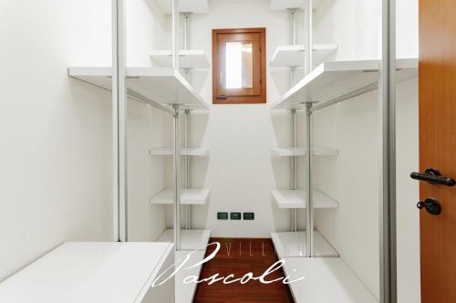 una habitación con estanterías blancas en la pared en Villino Pascoli (in centro storico), en Cesenatico