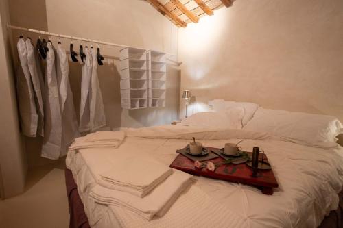 a white bed with a tray of food on it at I COCCI DEL CASTELLO CASAVACANZE in Civitanova Alta