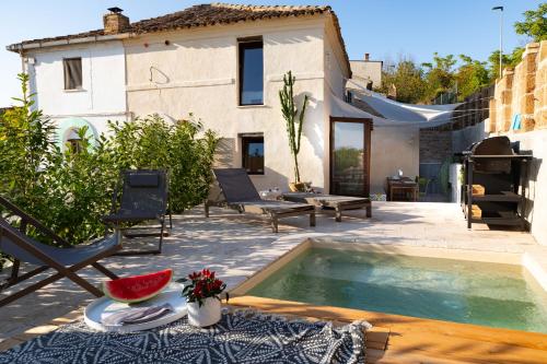 a villa with a swimming pool in front of a house at I COCCI DEL CASTELLO CASAVACANZE in Civitanova Alta