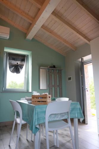 a dining room with a table and white chairs at Il Paradiso di Pietra in Filetto