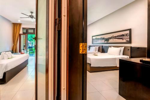 a hotel room with two beds and a bathroom at HOI AN HISTORIC HOTEL in Hoi An