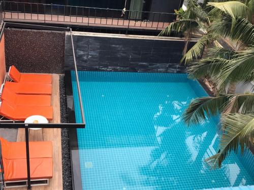 a swimming pool with two chairs and a palm tree at V20 Boutique Jacuzzi Hotel in Bangkok