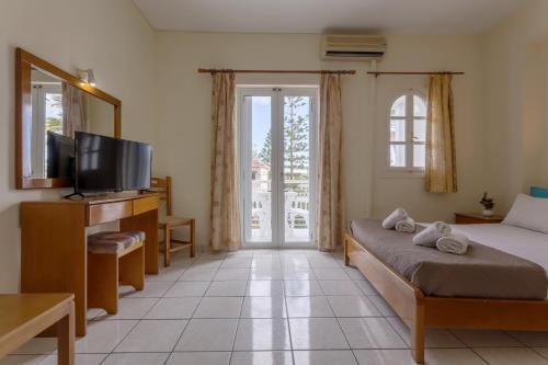 a bedroom with a bed and a tv and a window at Laganas Holidays Hotel in Laganas