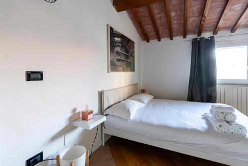 a white bedroom with a bed and a window at I BIMBI Apartments in Livorno