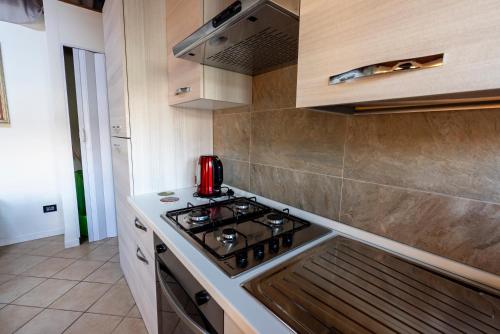 a kitchen with a stove top oven next to a counter at I BIMBI Apartments in Livorno