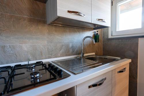 a kitchen with a sink and a stove at AFFITTACAMERE I BIMBI in Livorno