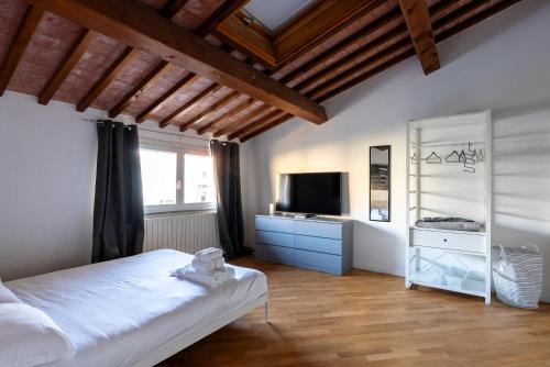 a bedroom with a white bed and a television at AFFITTACAMERE I BIMBI in Livorno