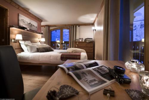 Habitación de hotel con cama y escritorio con sidra de mesa en Le Hameau de la Sapinière, en Les Menuires