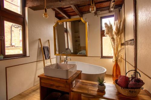 y baño con bañera, lavabo y espejo. en Sous les toits de Sainte-Cécile en Albi