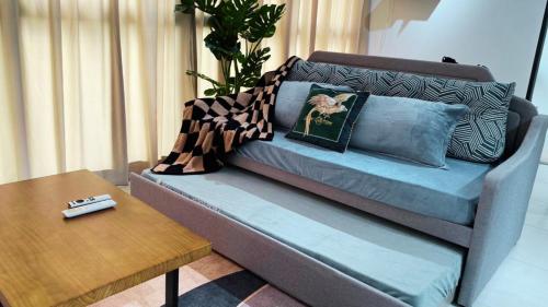 a couch with pillows and a table in a living room at DeLuma-Urban Suites in Jelutong