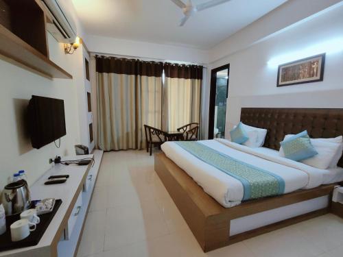 a hotel room with a bed and a television at Gazebo Inn & Suites Medanta in Gurgaon