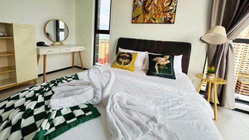 a bedroom with a large white bed with a mirror at DeLuma-Urban Suites in Jelutong