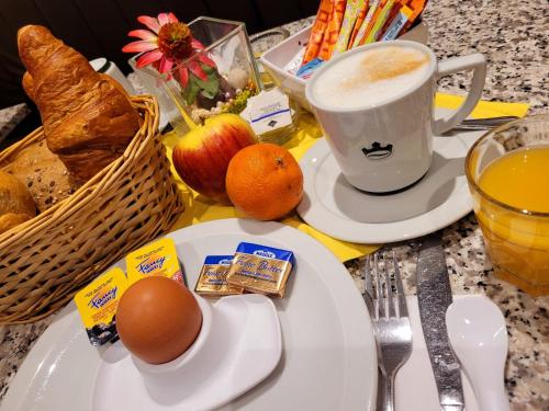 a breakfast table with a cup of coffee and a plate of food at Hotel Christina in Cologne