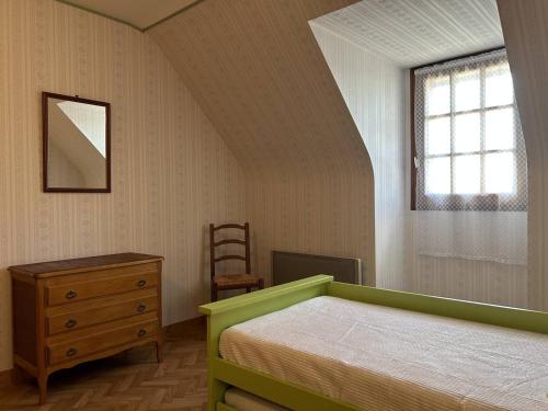 une chambre avec un lit, une commode et une fenêtre dans l'établissement 802 - Maison avec jardin à quelques pas du centre bourg d'Erquy, à Erquy
