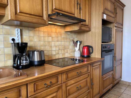 une cuisine avec des armoires en bois et un four à plaques de cuisson dans l'établissement 802 - Maison avec jardin à quelques pas du centre bourg d'Erquy, à Erquy