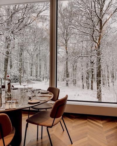 a dining room with a table and chairs and a window at Hotel Dolce La Hulpe Brussels in La Hulpe
