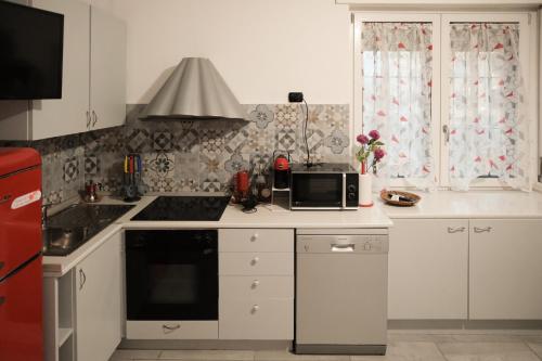 La cuisine est équipée de placards blancs et d'un four micro-ondes. dans l'établissement La Casa di Zoe, à Locate di Triulzi