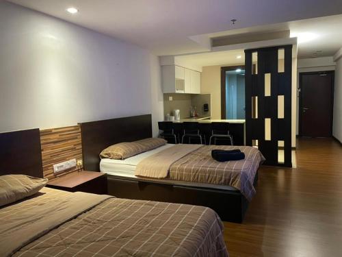 um quarto de hotel com duas camas e uma cozinha em Staycity Apartments - Kota Bharu City Point em Kota Bharu