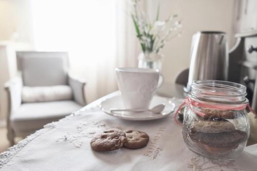 uma mesa com um prato de biscoitos e uma chávena de café em Casina Le Conserve em Cesenatico