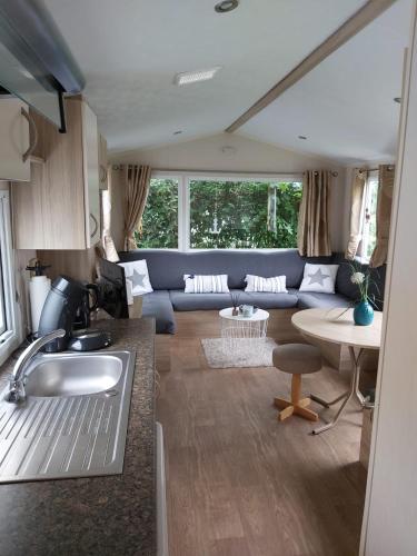 a caravan kitchen and living room with a couch at Beach Resort Kamperland - 642 in Kamperland