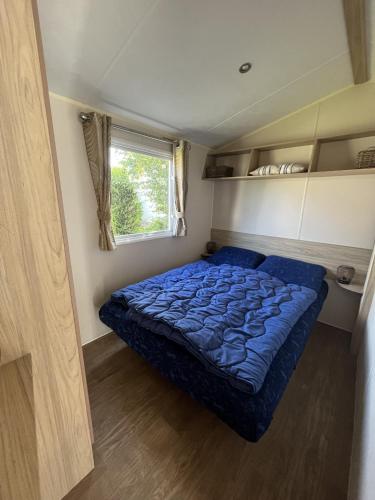 a bedroom with a blue bed in a small room at Beach Resort Kamperland - 642 in Kamperland