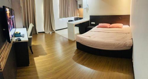 um quarto com uma cama com duas almofadas cor-de-rosa em Staycity Apartments - Kota Bharu City Point em Kota Bharu