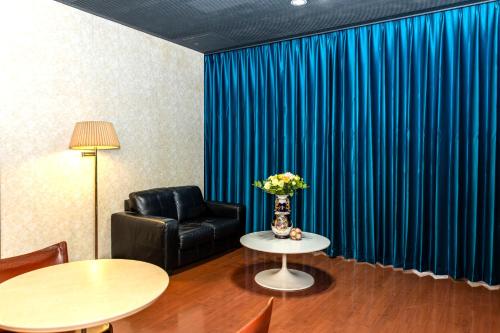 a living room with a black leather chair and a table at Higashi Kumamoto Business Center in Ozu