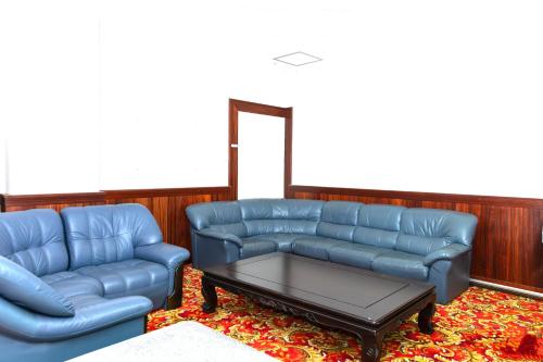 a living room with two blue couches and a coffee table at Higashi Kumamoto Business Center in Ozu