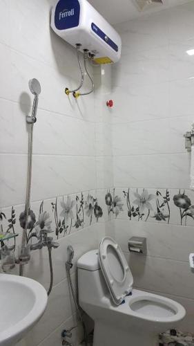 a bathroom with a toilet and a blow dryer on the wall at Love Hotel Hà Đông HN - by BAY LUXURY in Hà Ðông