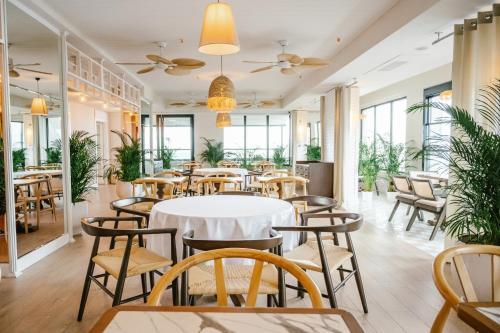 a restaurant with tables and chairs and windows at The Grandeur Hotel in Batumi