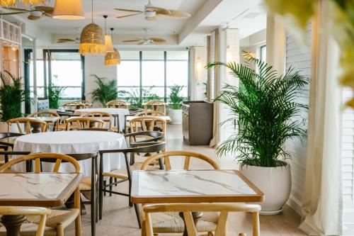 a restaurant with tables and chairs and potted plants at The Grandeur Hotel in Batumi