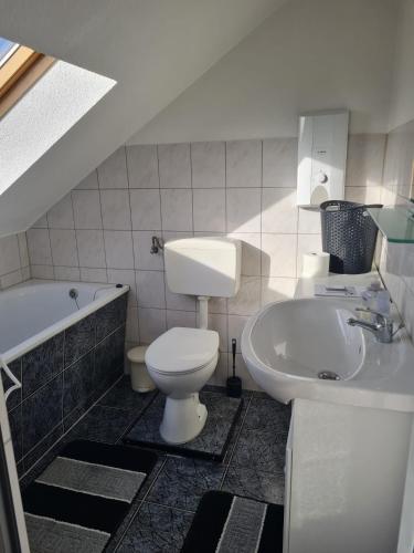 een badkamer met een toilet, een wastafel en een bad bij MM Apartment Wesseling in Wesseling