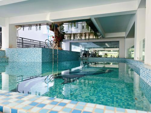 a swimming pool in a building with blue tiles at Arc de Triomphe apartment in Vientiane